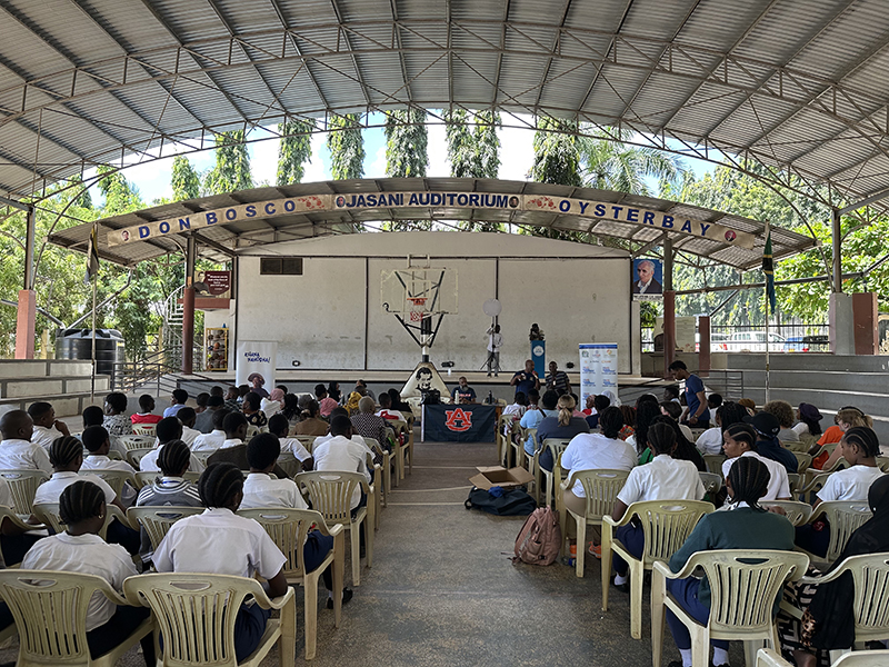 Large group of students in an open-air auditorium.