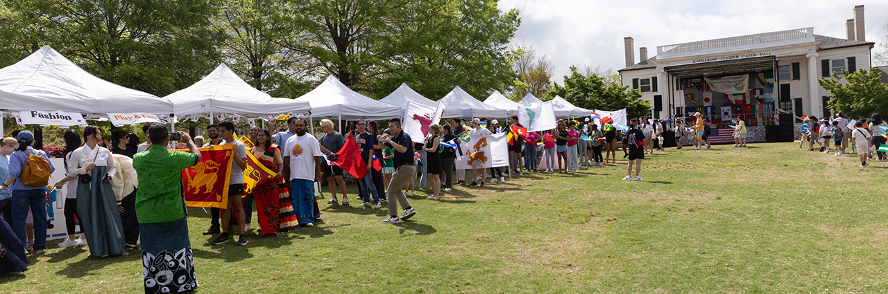 People walking and carrying flags on a field.